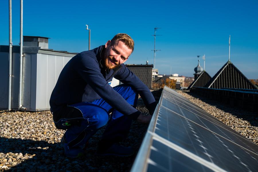 WETABO-Mitarbeiter montiert eine Photovoltaikanlage auf dem Dach